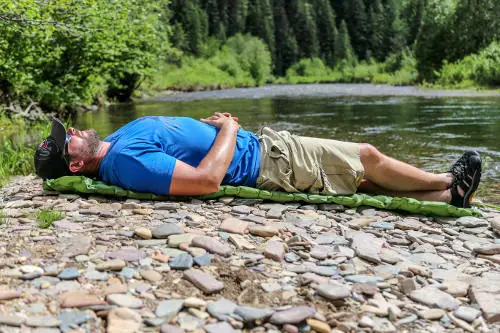 laying by the river outdoorsman lab